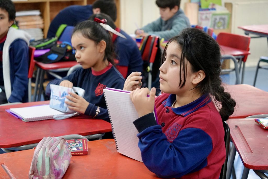 Estudiantes trabajando con sus cuadernos en la sala de clases