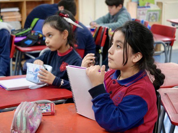 Estudiantes trabajando con sus cuadernos en la sala de clases
