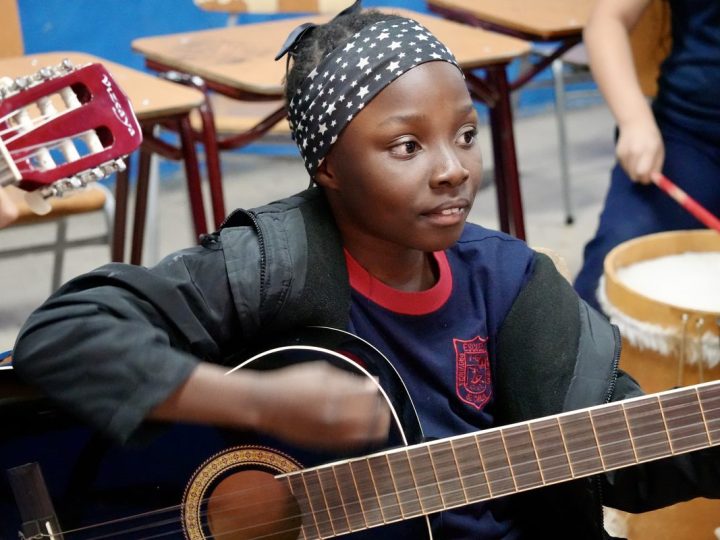 Estudiantes tocando instrumentos en el taller de música