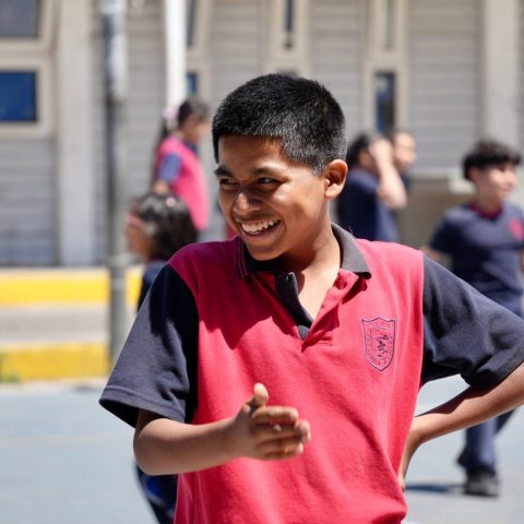 Estudiante sonriendo en el patio de la escuela