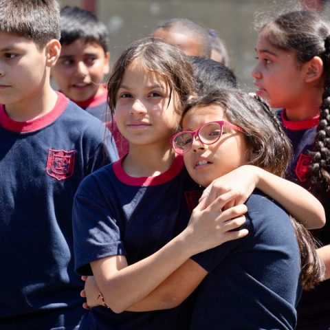 Dos estudiantes abrazadas en el patio de la escuela