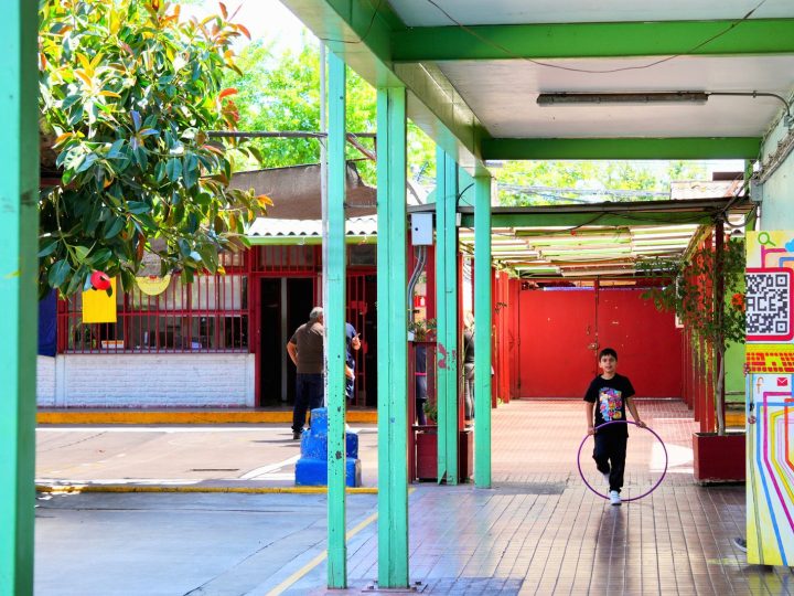 Estudiante jugando con un aro en el patio techado de la escuela